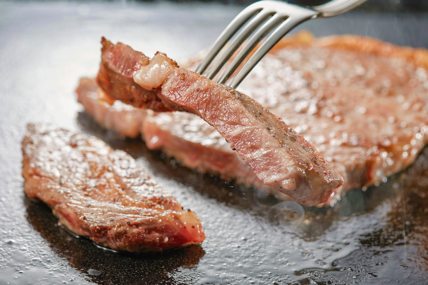 ジューシーでやわらかい、熱々のステーキ ※調味牛脂を注入した加工肉です